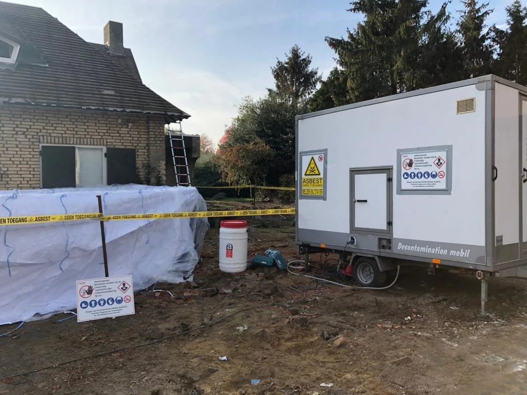 Cordoned-off asbestos area and decontamination shower trailer